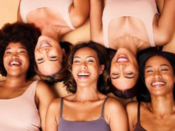 Grupo de cinco mulheres sorrindo e abraçadas representando a diversidade e beleza de Niely Gold