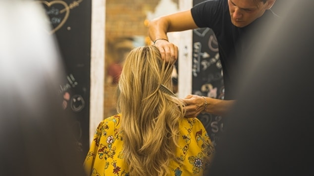 Profissional faz camadas longas nos cabelos longos ou cabelão de sua cliente